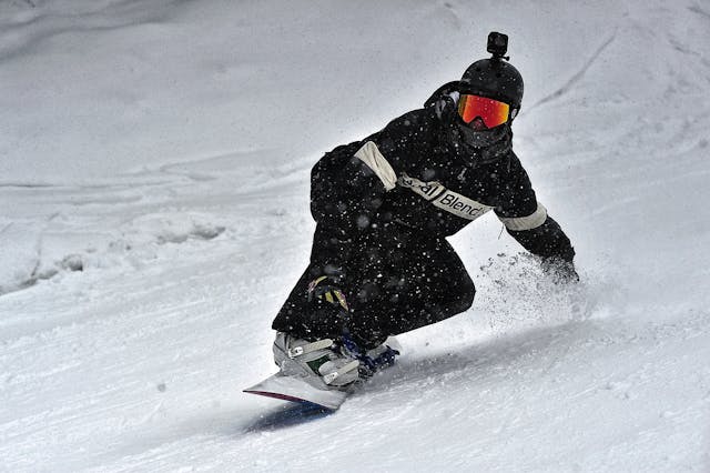 persoon-in-zwarte-jas-en-zwarte-broek-rijden-op-snowboard